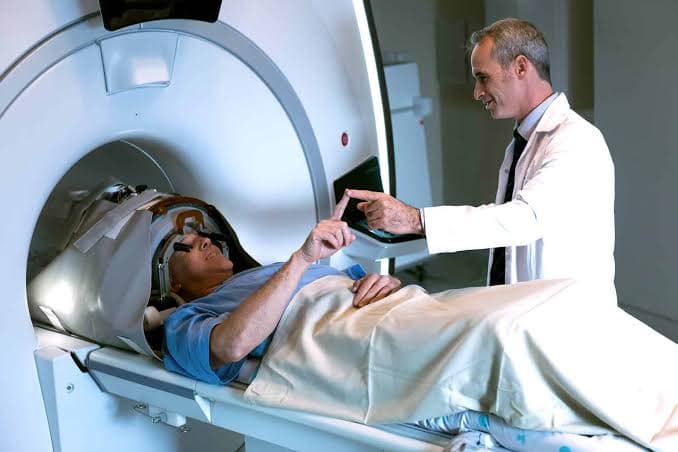 Doctor communicating with a patient during MRI-guided focused ultrasound treatment.