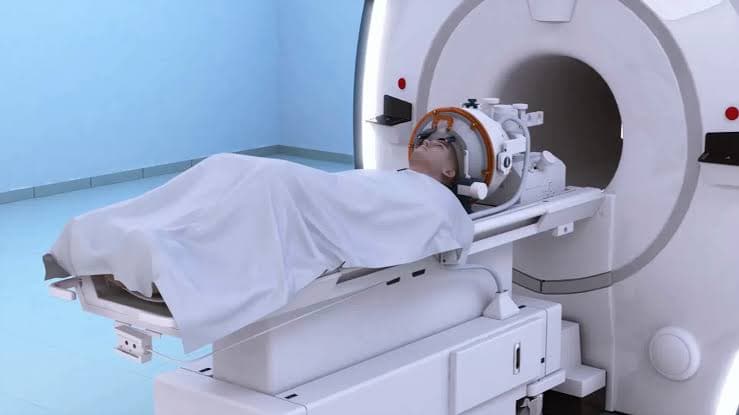 Patient positioned inside an MRI system configured for focused ultrasound treatment.